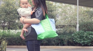 Green Baby Garden :: Retail Imaging of Upcycling Product :: carrying melon green parent bag on shoulder