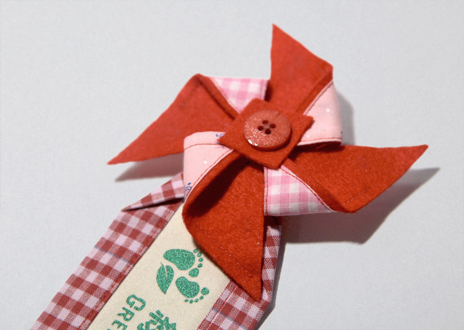 Green Baby Garden CNY edition uniform brooch with a red pinwheel