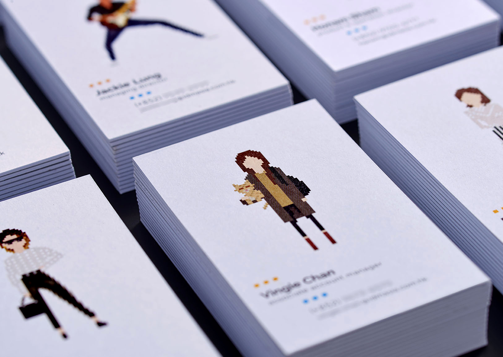 A leading Asian Digital Marketing Agency Brand based in Hong Kong and office in South Korea :: Identity Revamp and New Business Card Design :: business card, name card, 2 x 4, 8 decks, dynamic branding, personalisation pixelated figures of every individuals, black table top, focusing on VC young girl holding a cat, anglar view