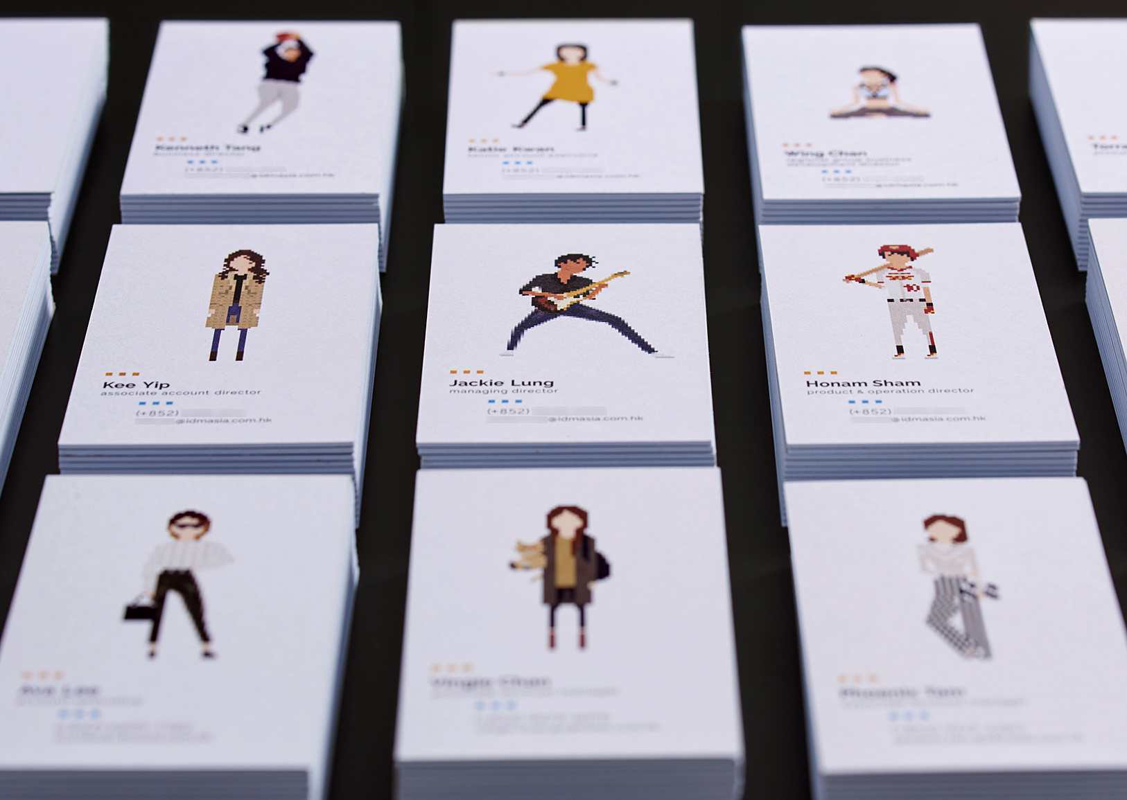 A leading Asian Digital Marketing Agency Brand based in Hong Kong and office in South Korea :: Identity Revamp and New Business Card Design :: business card, name card, 3 x 5, 15 decks, dynamic branding, personalisation pixelated figures of every individuals, black table top, anglar view focusing on middle JL guitarist in action